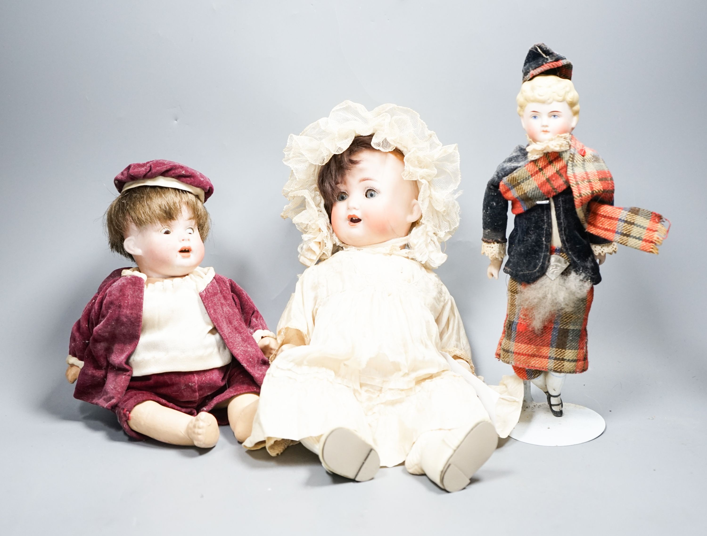 A German bent limb face cracked H12in. German bent limb character baby H9in. bisque head Scottish doll with bisque shoes and hands H10in.